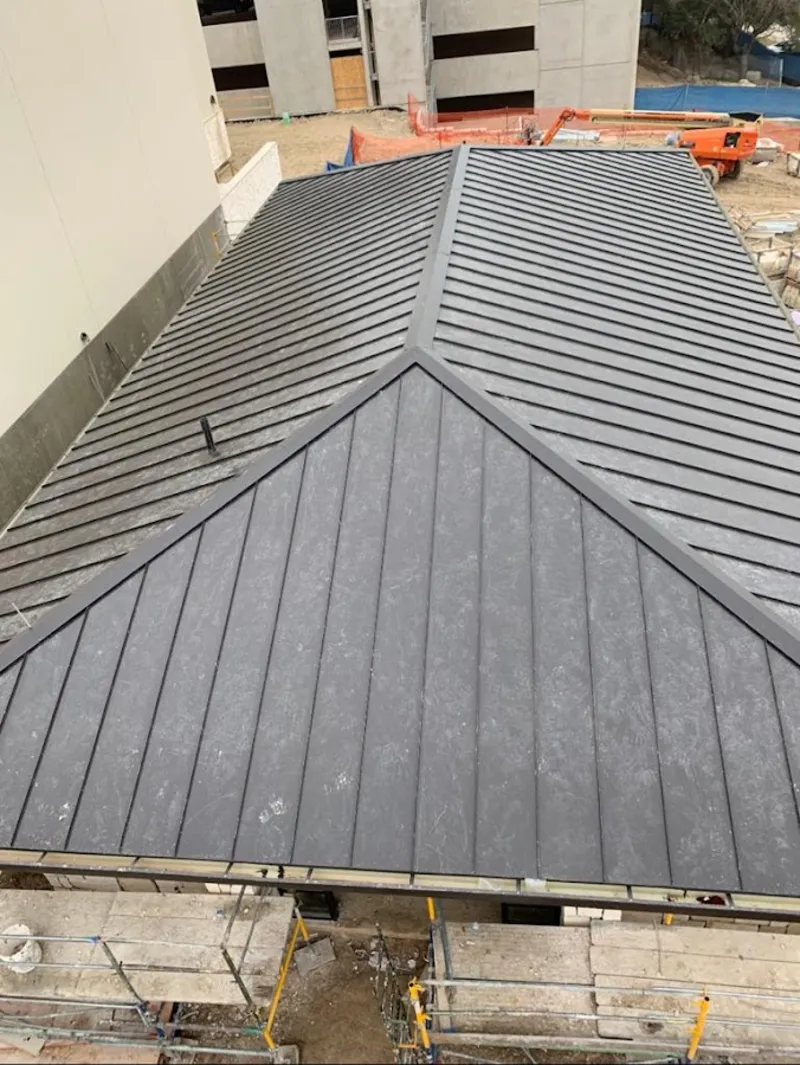 Commercial metal roof construction with crane equipment in Milford Mill